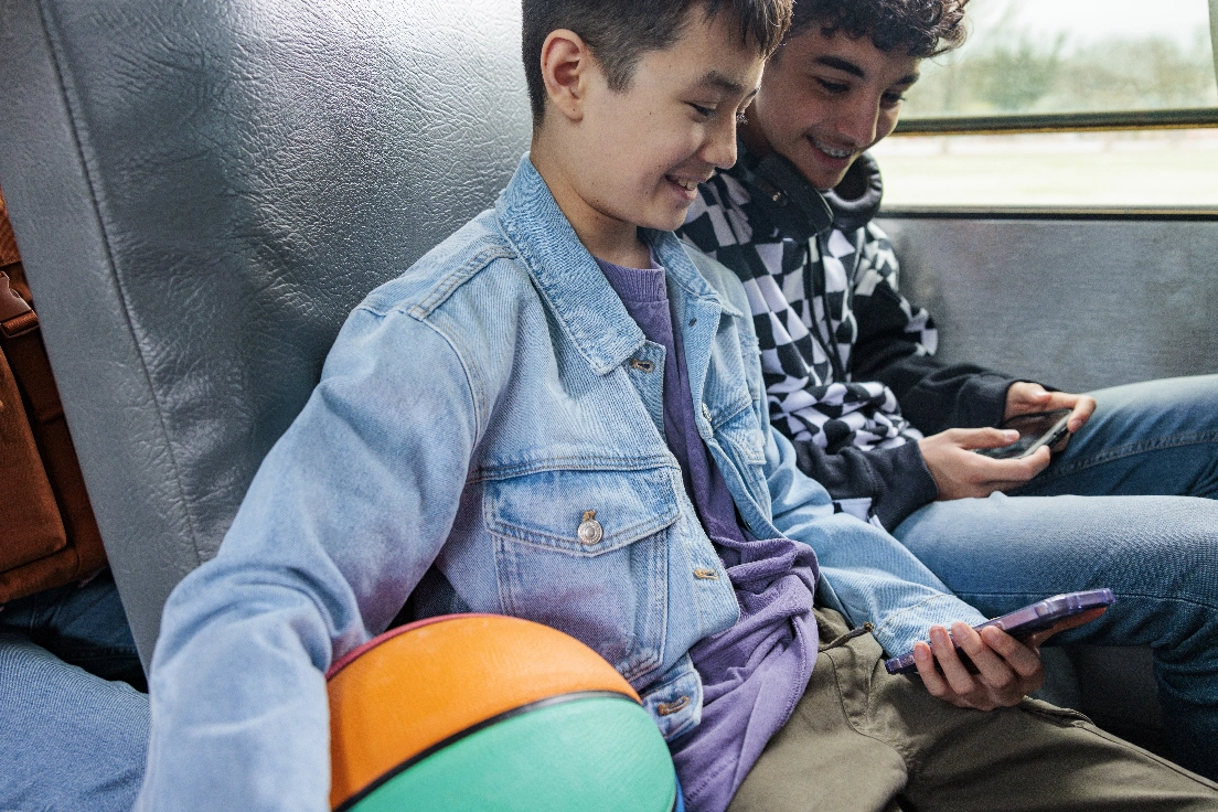 jóvenes jugando con celular en autobús escolar