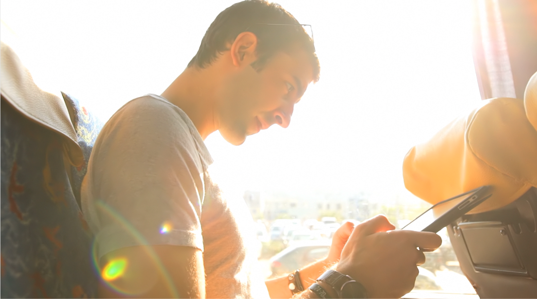 hombre revisando su celular en un autobús